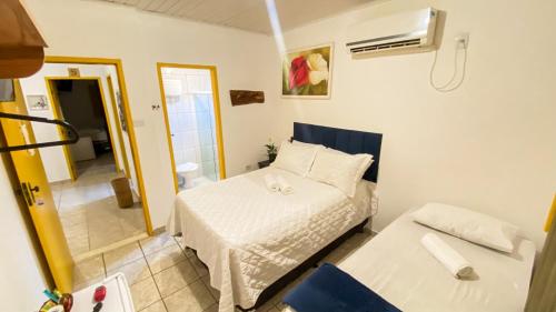 a small room with a bed and a mirror at Pousada Canto dos Pássaros in Lençóis