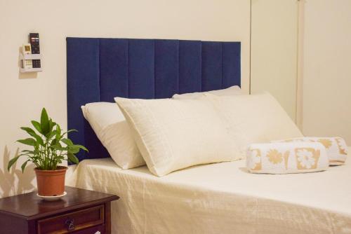 a bed with white pillows and a blue headboard at Pousada Canto dos Pássaros in Lençóis