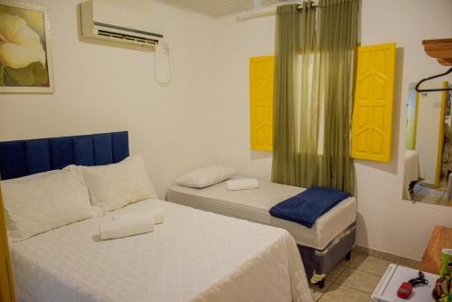 a small bedroom with two beds and a window at Pousada Canto dos Pássaros in Lençóis
