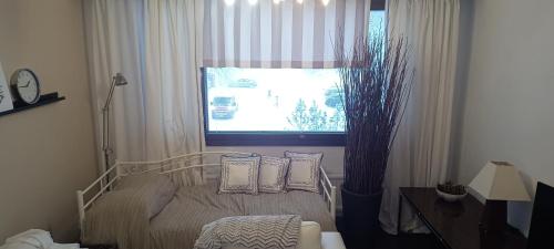 a bedroom with a bed with pillows and a window at Lohja Lempola 2 room apartment in Lohja