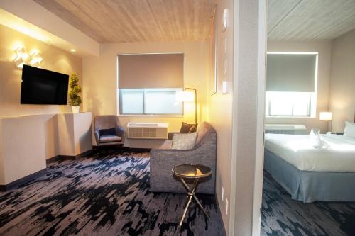a hotel room with a bed and a couch and a bed and a tv at Fairfield Inn & Suites By Marriott New York Brooklyn in Brooklyn