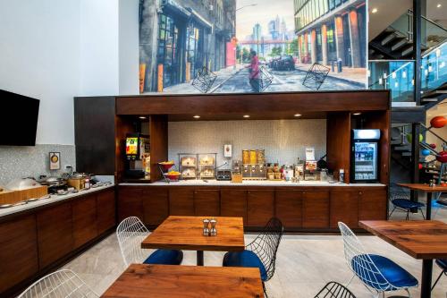 a restaurant with tables and chairs and a counter at Fairfield Inn & Suites By Marriott New York Brooklyn in Brooklyn