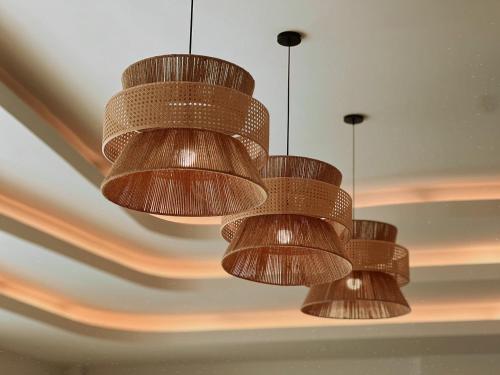 three brown chandeliers hanging from a ceiling at De Beach pool villa เดิน 3 นาทีจากชายหาด in Jomtien Beach
