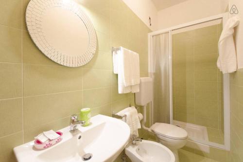 a bathroom with a sink and a toilet and a mirror at Casa Martina in Pescara