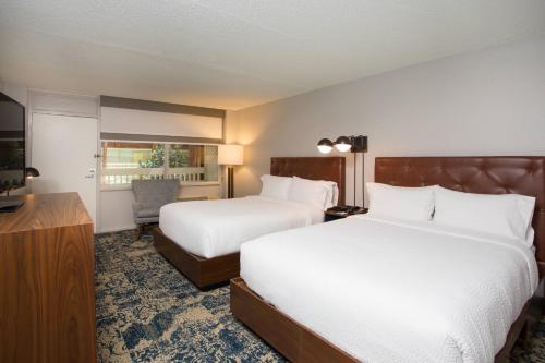 a hotel room with two beds and a television at Four Points by Sheraton Eastham Cape Cod in Eastham