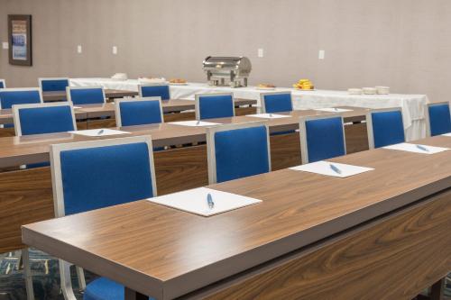a classroom with wooden tables and blue chairs at Four Points by Sheraton Eastham Cape Cod in Eastham