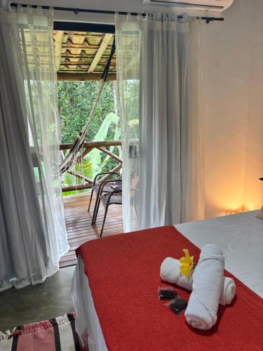 a bedroom with a bed with towels and a window at Casa Recanto das arvores in Itacaré