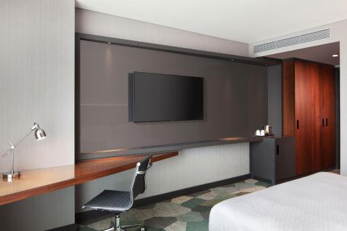 a hotel room with a desk and a television on a wall at Four Points by Sheraton Istanbul Kagithane in Istanbul