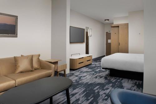 a hotel room with a couch and a bed and a tv at Fairfield Inn & Suites by Marriott Santa Rosa Rohnert Park in Rohnert Park