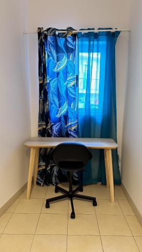 a desk with a chair in front of a blue curtain at Centrally Located Gzira in Il-Gżira