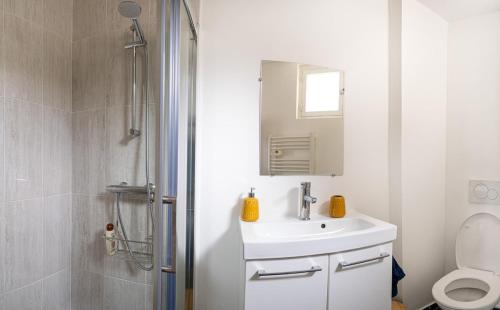 une salle de bain blanche avec un lavabo et une douche dans l'établissement Tous à la Plage Lit King Size, au Havre