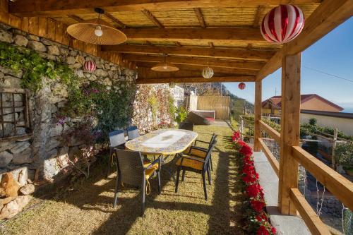 an outdoor table and chairs under a wooden pergola at Salvo's House in Furore