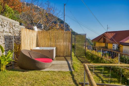 a backyard with a chair and a fence at Salvo's House in Furore