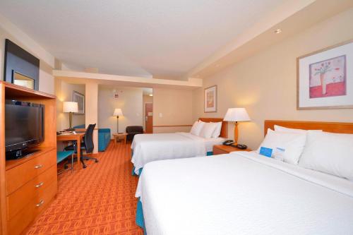 a hotel room with two beds and a flat screen tv at Fairfield Inn and Suites by Marriott Williamsport in Williamsport