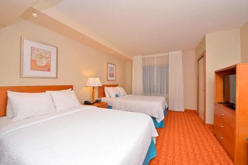 a hotel room with two beds and a television at Fairfield Inn and Suites by Marriott Williamsport in Williamsport