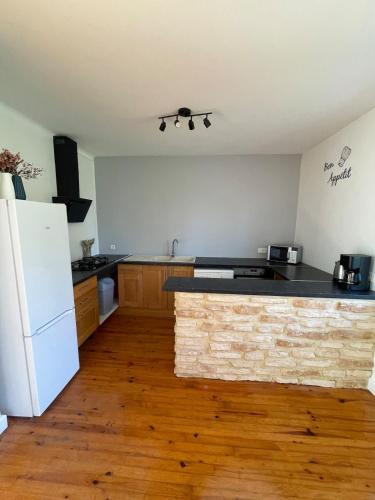 une cuisine avec un réfrigérateur blanc et un comptoir dans l'établissement La Maison Lilas, à Messeix