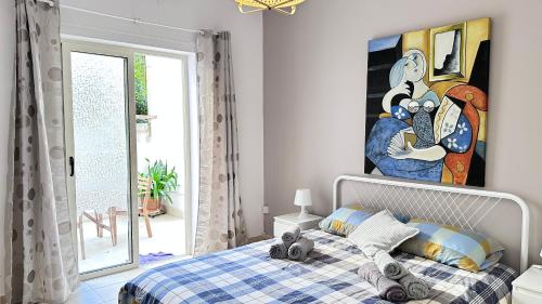 a bedroom with a bed with a painting on the wall at Centrally Located Gzira in Il-Gżira