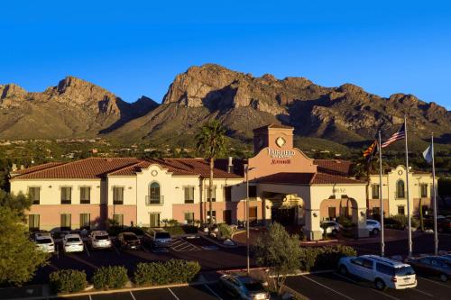 a hotel with cars parked in a parking lot in front of a mountain at Fairfield Inn & Suites Tucson North/Oro Valley in Oro Valley