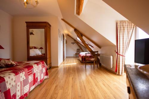 a bedroom with a bed and a staircase in a room at Ferme de Marpalu in La Ferté-Saint-Cyr