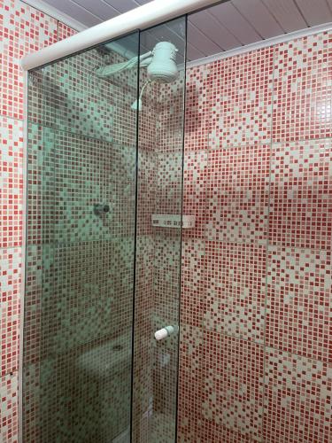 a shower with a glass door in a bathroom at Pousada Casa do Nilo in Ilha do Mel