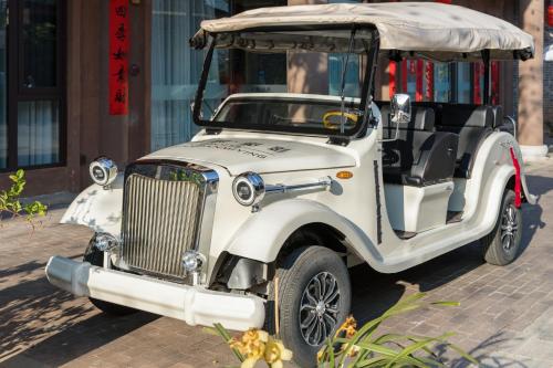 an old white golf cart parked on a street at Dianpan Miying Hotel in Shizui Zhan