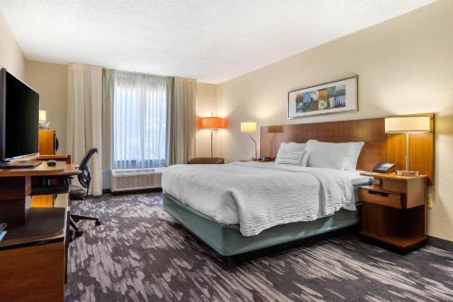 a hotel room with a bed and a flat screen tv at Fairfield Inn Myrtle Beach North in Myrtle Beach
