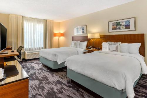 a hotel room with two beds and a flat screen tv at Fairfield Inn Myrtle Beach North in Myrtle Beach