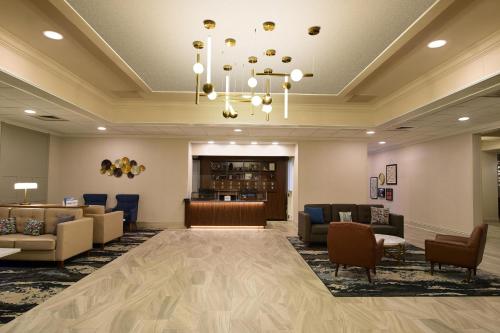 a lobby with a waiting room with couches and a chandelier at Four Points by Sheraton York in York