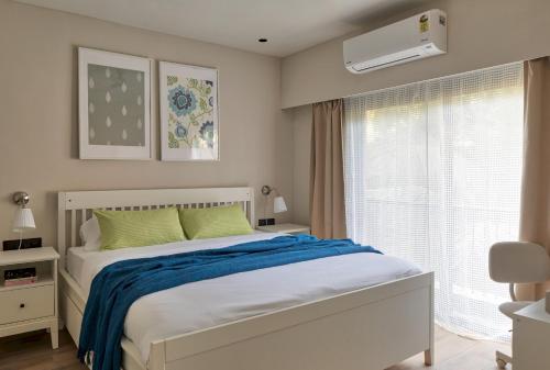 En eller flere senge i et værelse på Koral 1BHK Apartment by tisyastays