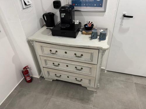 a white dresser with a coffee maker on top of it at Gemütliches Kellerzimmer + Bad in Bocholt
