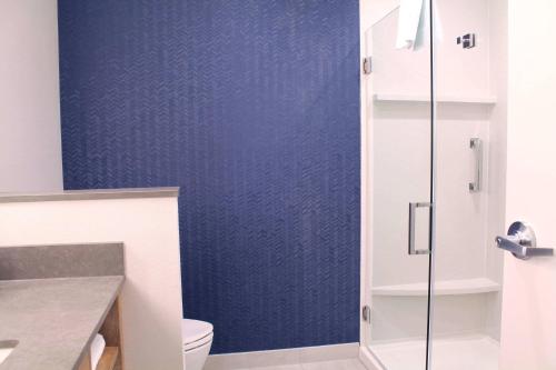 a bathroom with a toilet and a blue wall at Fairfield by Marriott Inn & Suites St Louis South in Saint Louis