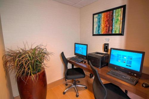 a office with two computers on a desk with a plant at Fairfield Inn & Suites By Marriott Jupiter in Jupiter