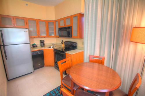 a small kitchen with a table and a refrigerator at Fairfield Inn & Suites By Marriott Jupiter in Jupiter