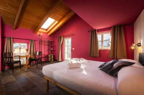 CerciventoにあるB&B In Plaitのピンクの壁のベッドルーム1室、ベッド1台(テーブル付)