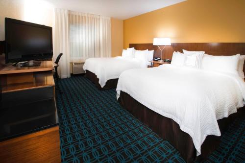 a hotel room with two beds and a flat screen tv at Fairfield Inn & Suites Idaho Falls in Idaho Falls
