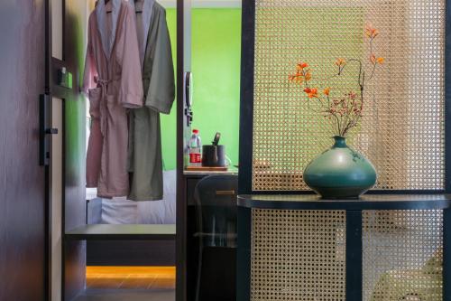 a green vase sitting on a table in a closet at Dianpan Miying Hotel in Shizui Zhan