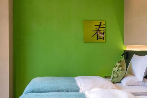 a green bedroom with a bed and a picture on the wall at Dianpan Miying Hotel in Shizui Zhan
