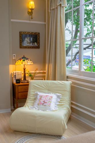 a white couch in a living room with a window at Camellia Full House in Da Nang