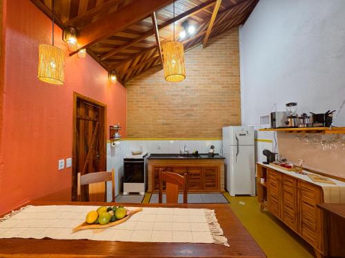 a kitchen with a table with a bowl of fruit on it at Chalé Seio de Minas in Gonçalves