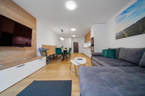 ein Wohnzimmer mit Couch und Tisch in der Unterkunft Apartmány Rezidence Lyžařská in Janské Lázně
