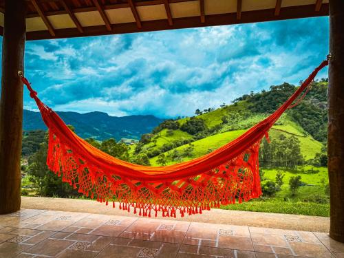 a red hammock with a view of a mountain at Chalé Seio de Minas in Gonçalves