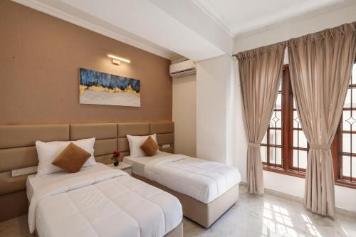 a bedroom with two beds and a window at Emerlad Apartment 201 Nr MG Road Housekeeping in Bengaluru