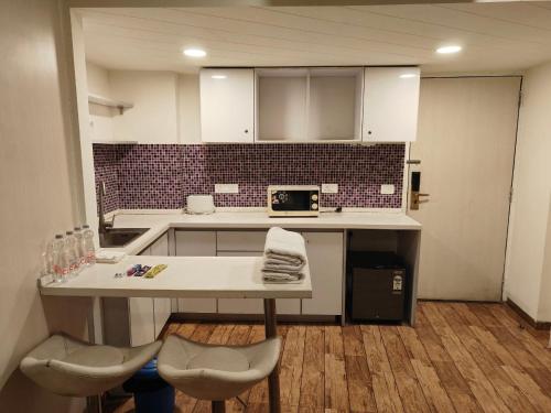 a kitchen with a table and chairs in a room at Rajhansh Belliza Nest - A Luxury 2BHK Apartment in Surat