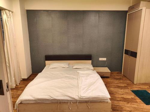 a bedroom with a large bed with white sheets at Rajhansh Belliza Nest - A Luxury 2BHK Apartment in Surat