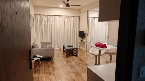 a living room with a sink and a table in a room at Rajhansh Belliza Nest - A Luxury 2BHK Apartment in Surat