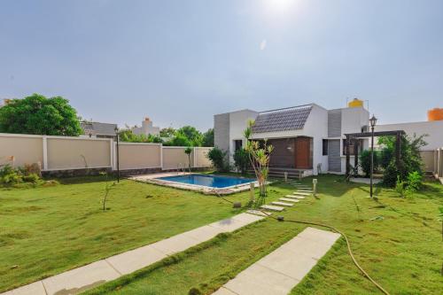 a house with a swimming pool in a yard at JhilMil Pool Villa by StayJadeParty VillaLawn in Hosūr