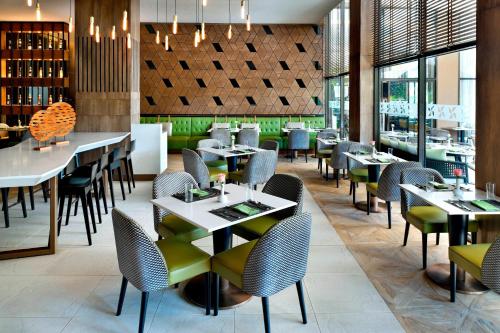 a dining room with tables and chairs and windows at Four Points By Sheraton Nairobi Hurlingham in Nairobi