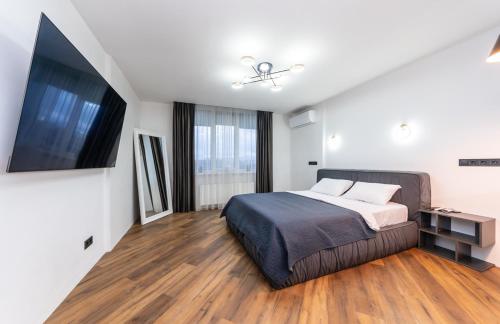 a bedroom with a bed and a flat screen tv at Люкс на Бориспільській ЖК Олімпік Парк, генератор на будинку in Kyiv