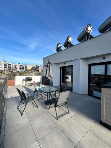 a patio with a table and chairs on a building at New apartment with large terrace in Matosinhos in Matosinhos