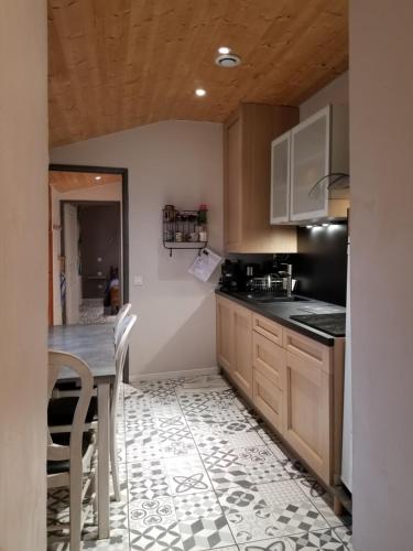 une cuisine avec des armoires en bois et une table et des chaises dans l'établissement Maison Centre Ville Parking privé, à Ax-les-Thermes